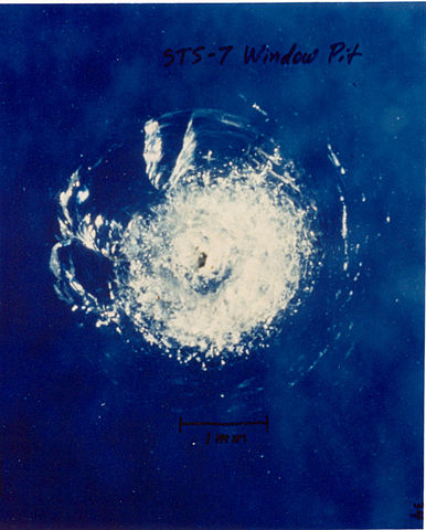 מכתש פגיעה בחלון תחנת החלל הבינלאומית במהלך משימה STS-7 משנת 1983 | צילום: NASA