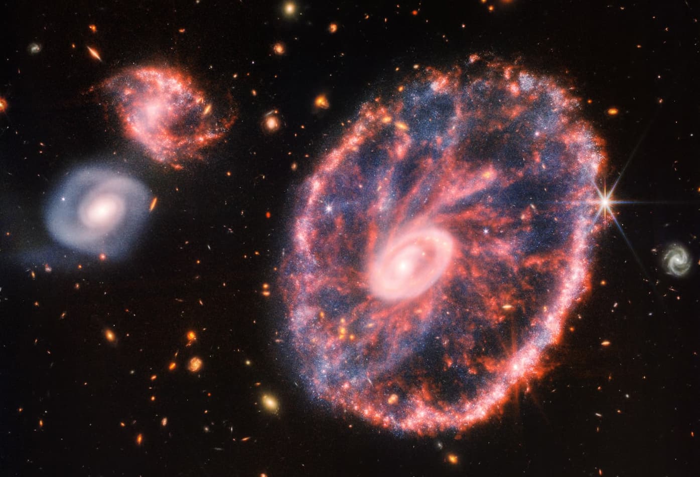 גלקסיית קארטוויל (במרכז), שנוצרה מהתמזגות מהירה ואלימה של שתי גלקסיות ספירליות, כמו אלו משמאל. קרדיט: NASA/ESA/CSA/STScI/JWST