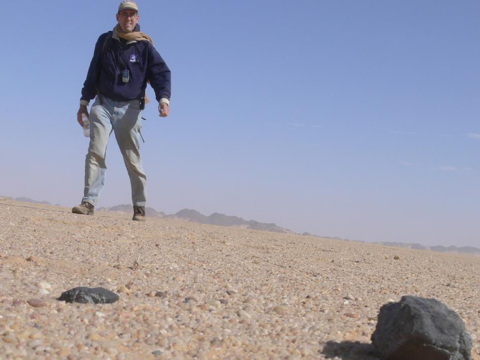 פיטר ג'ניסקנס, שהוביל את החיפוש מטעם מכון סט"י, מוצא מטאוריטים במדבר. קרדיט: NASA / SETI / P. Jenniskens