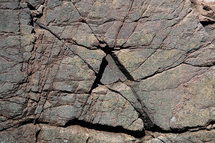גם בכדוה"א תמונות יכולות לתעתע. האם זו דלת סתרים משולשת? לא, סתם הצטלבות של קווי שבר בסלע באי הר המדבר במיין, ארה"ב. צילם: James St. John