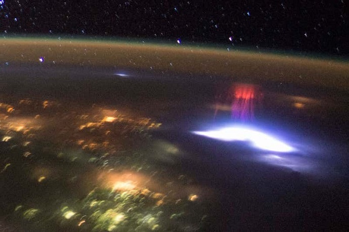 ברק (מלמטה) ומעליו שדון אדום בכדור הארץ, כפי שצולמו מתחנת החלל הבינלאומית. קרדיט: ISS/JSC/NASA