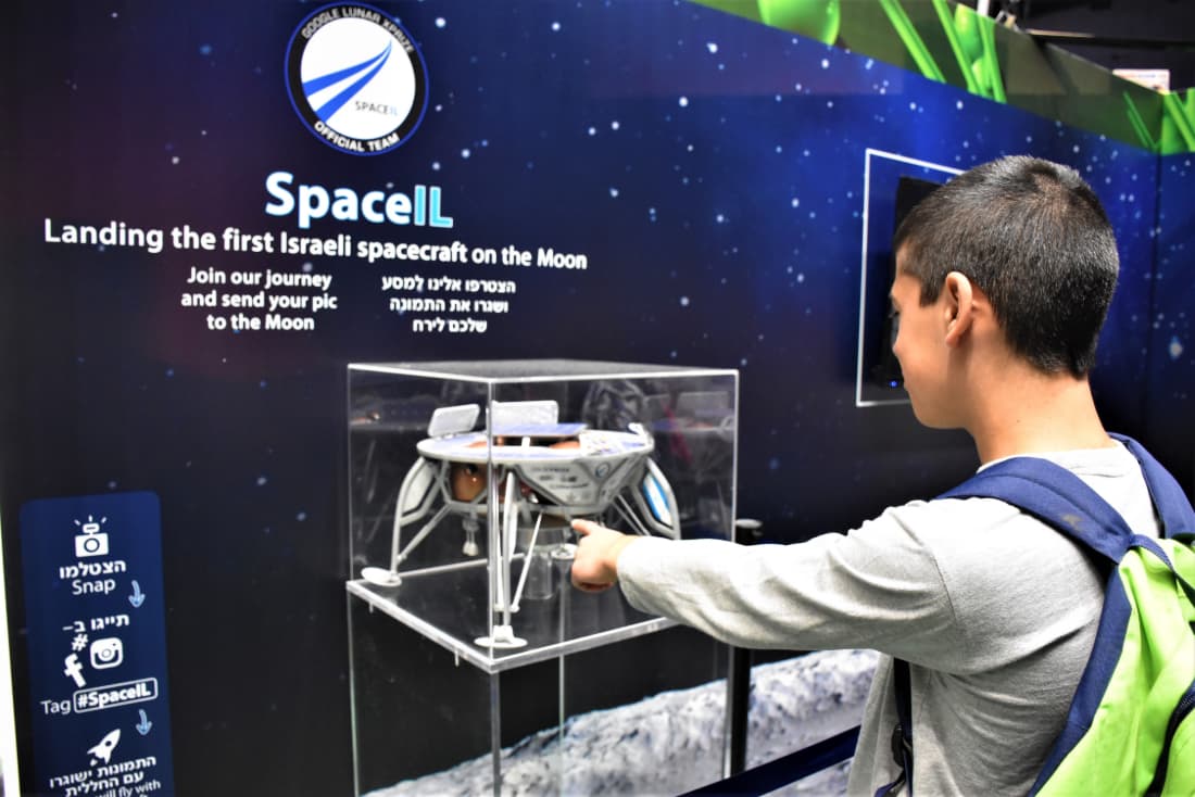 מכדור הארץ ועד הירח | באדיבות: SpaceIL תלמיד מצביע על דגם החללית