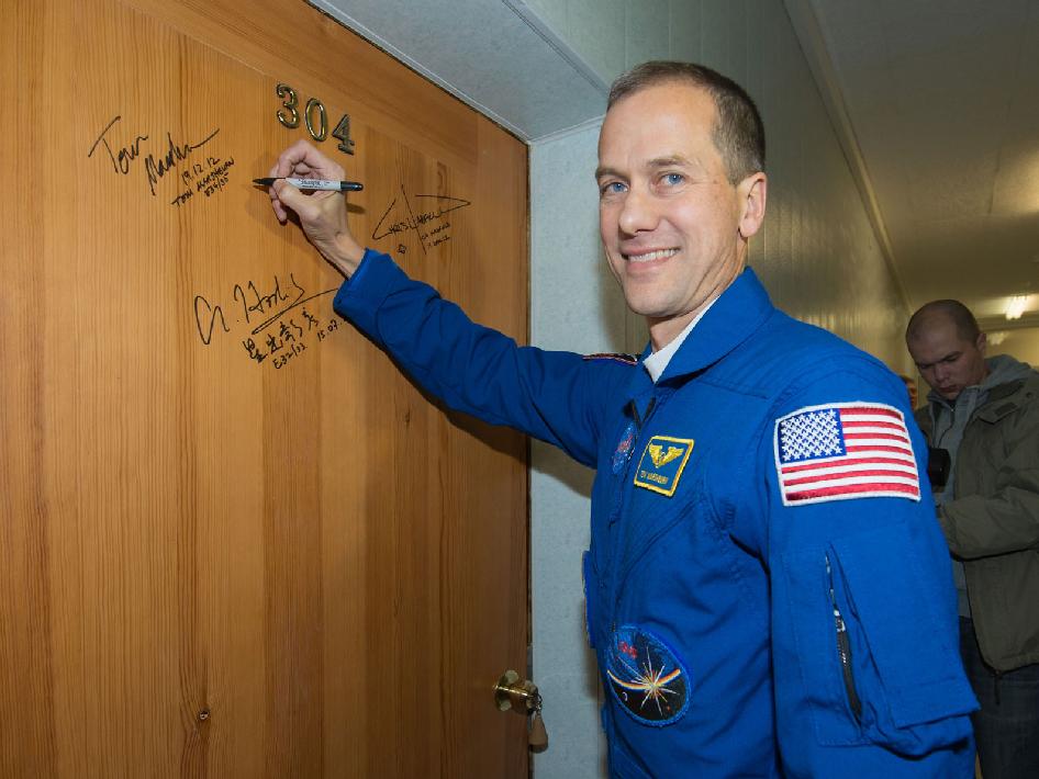 תומס מרשבורן חותם על דלת האסטרונאוטים, כמיטב המסורת לפני שיגורי סויוז 